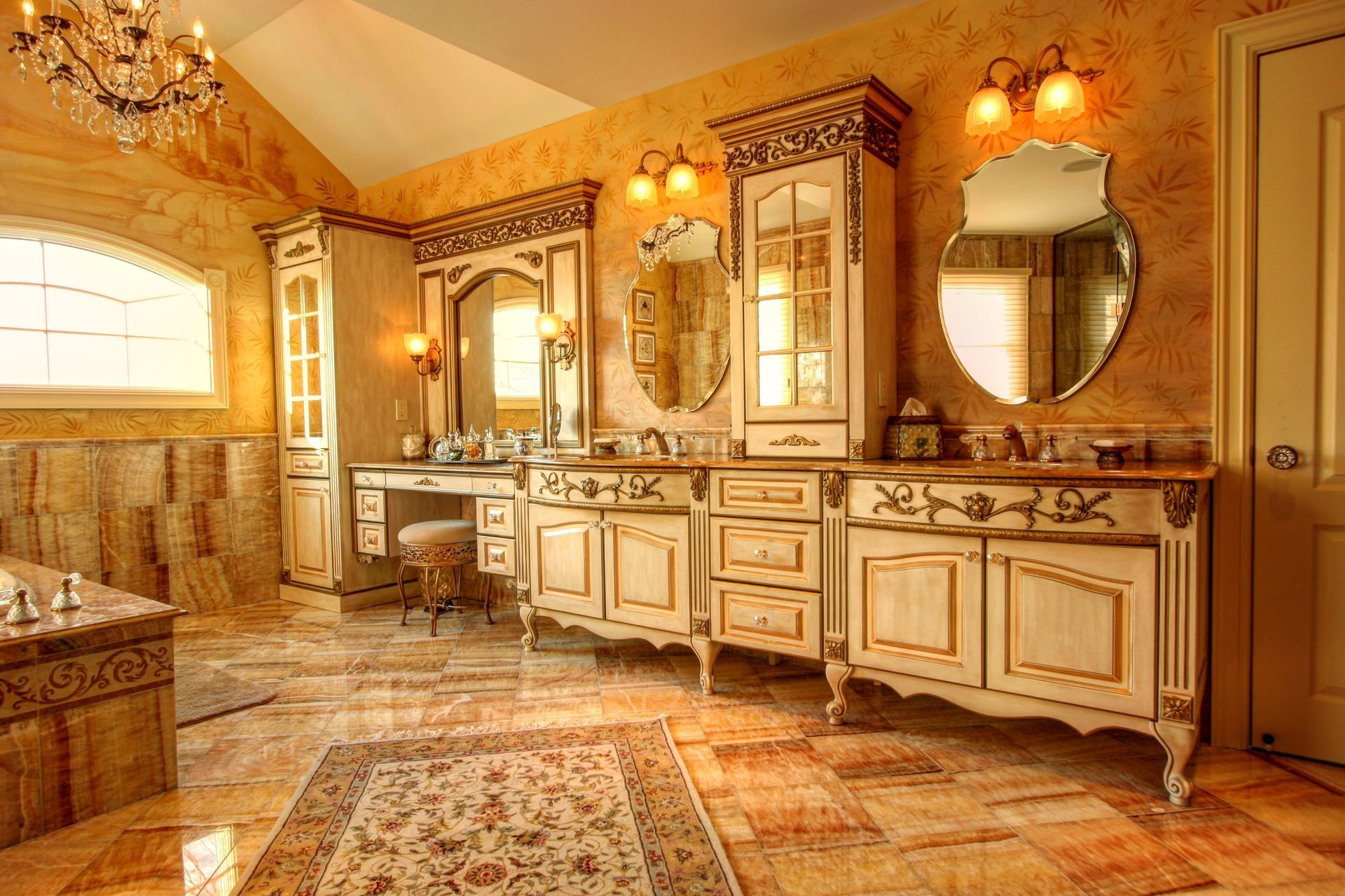 Ornate cream and gold custom bath vanity with arched mirrors and a makeup station