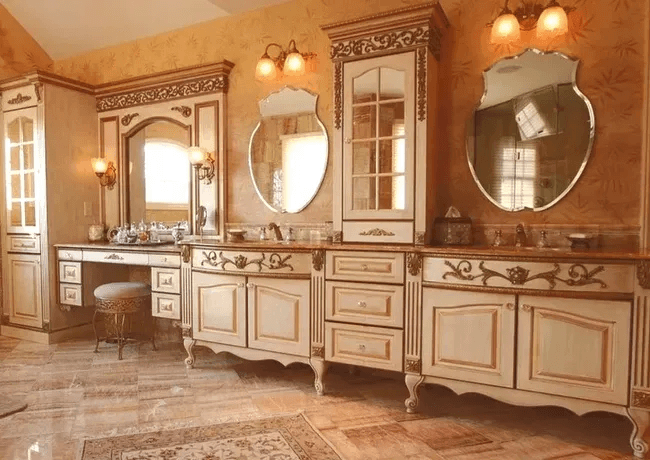Custom double bath vanity with carved cream cabinets and gilded mirrors
