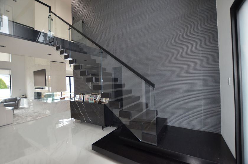 Custom glass railing on a floating black staircase